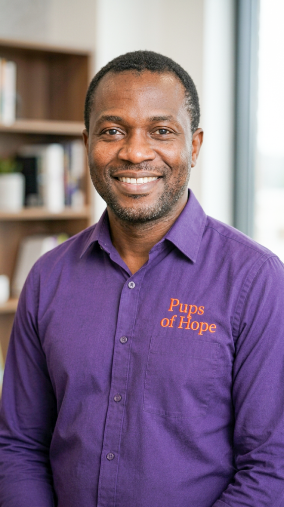 Smiling man wearing purple "Pups of Hope" shirt